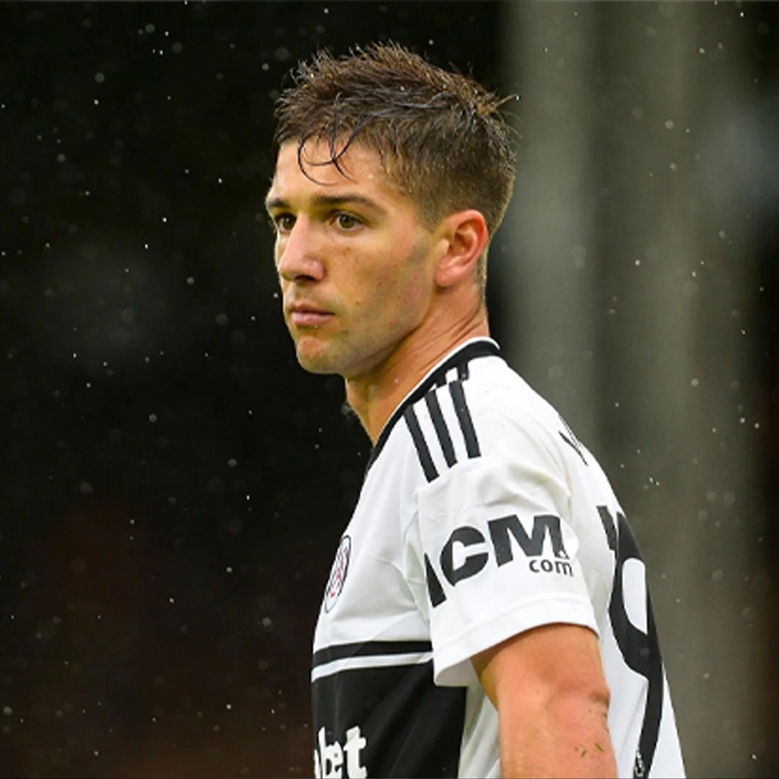 Fulham football player in a white shirt displaying historical ICM sleeve branding.
