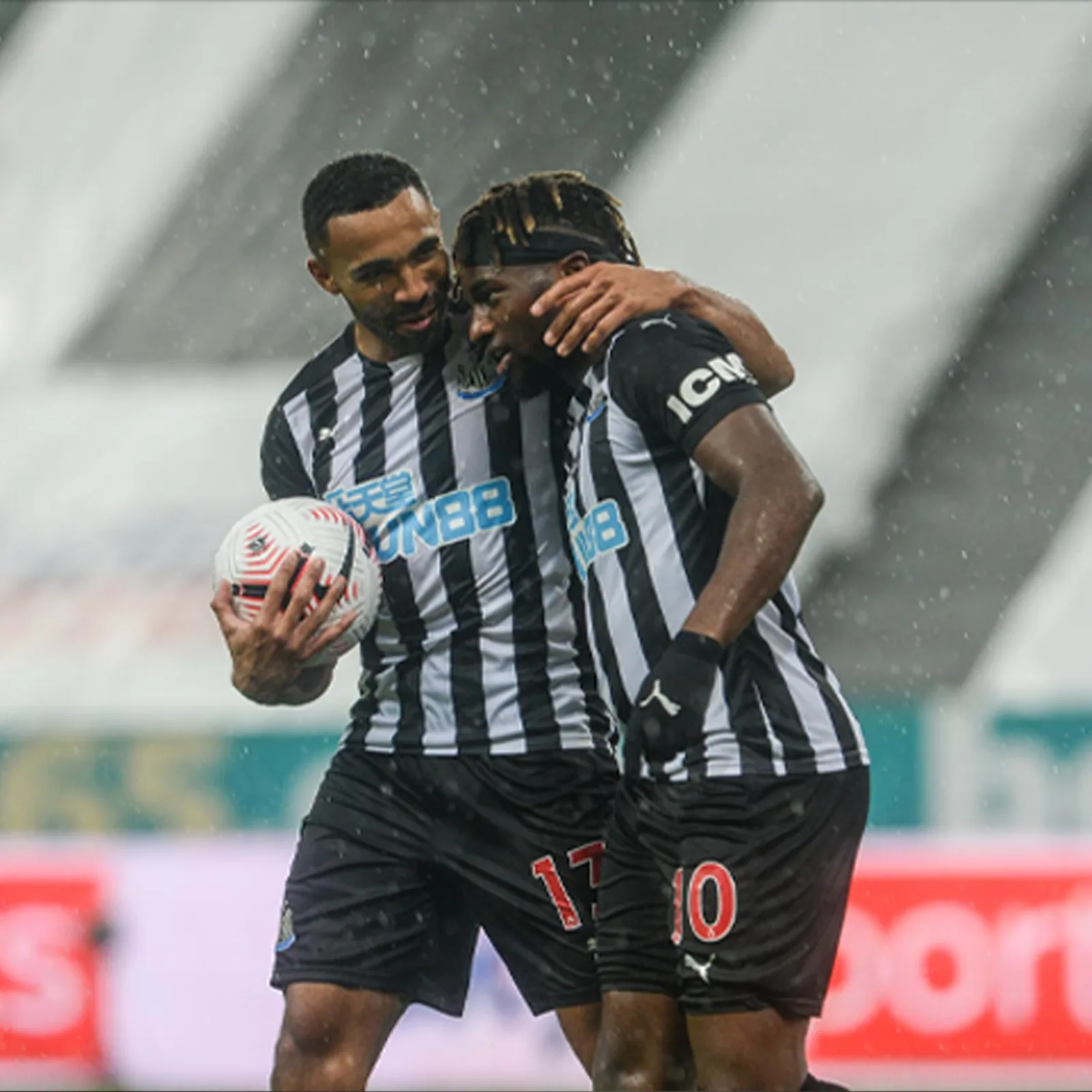 Newcastle United football players in black-and-white shirts displaying historical ICM sleeve branding.